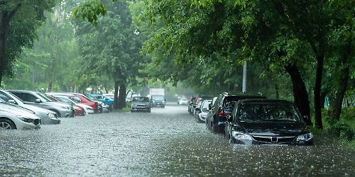 Überschwemmte Autos auf einer Straße bei Unwetter