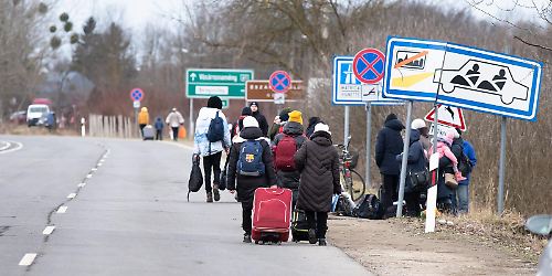 Flüchtlinge aus der Ukraine gehen an Straße entlang